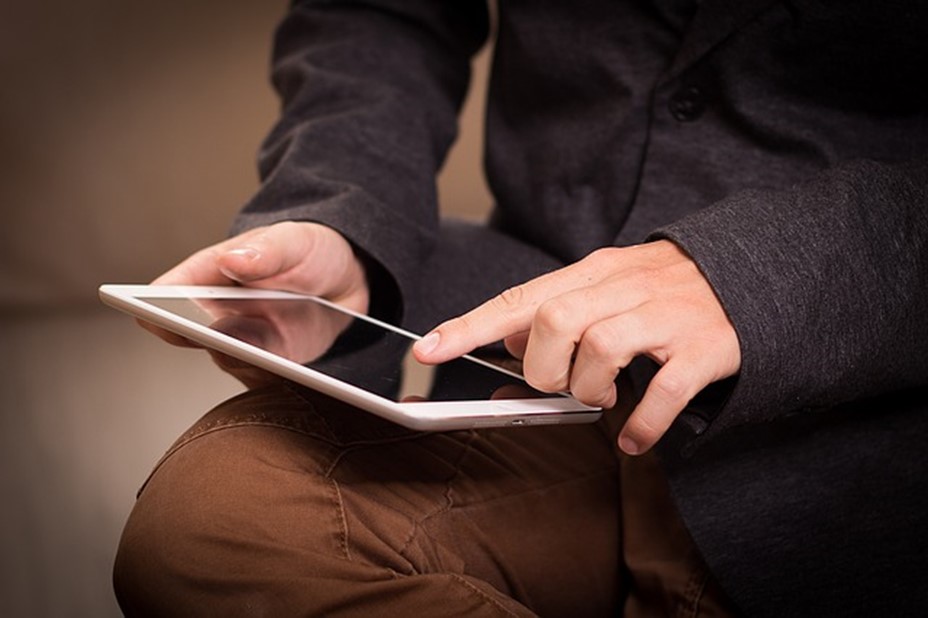 Homme lisant sur tablette électronique
